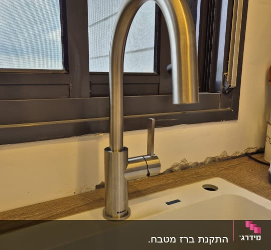 ברז נירוסטה מותקן בכיור מטבח לבן